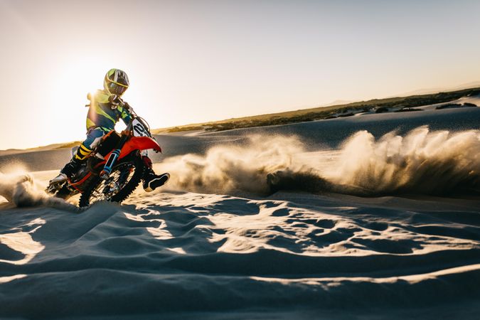 Motocross rider in action on sand dunes