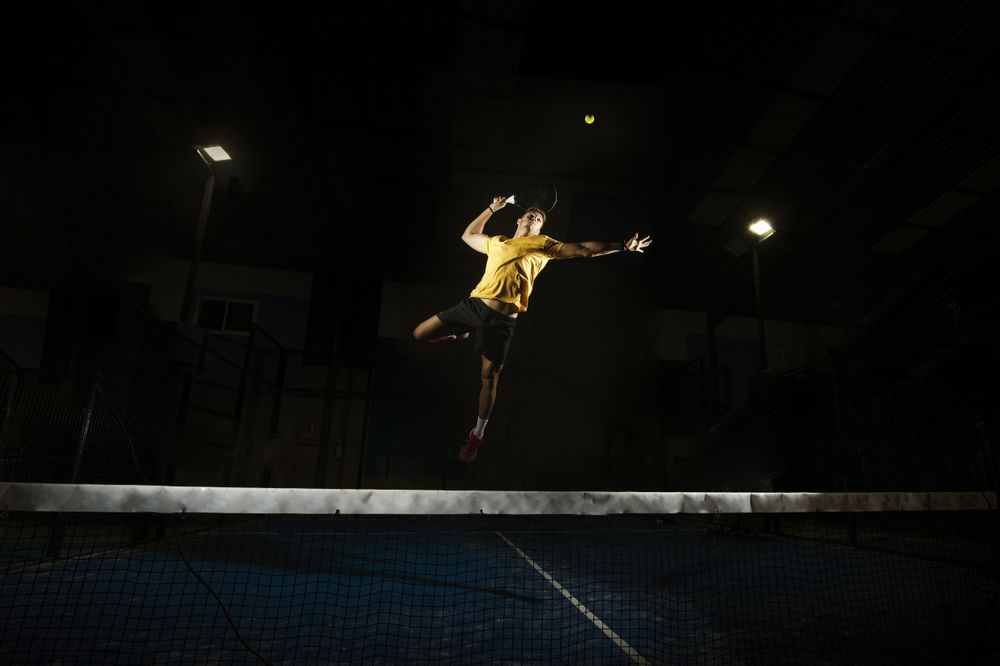 Man playing padel in darkness