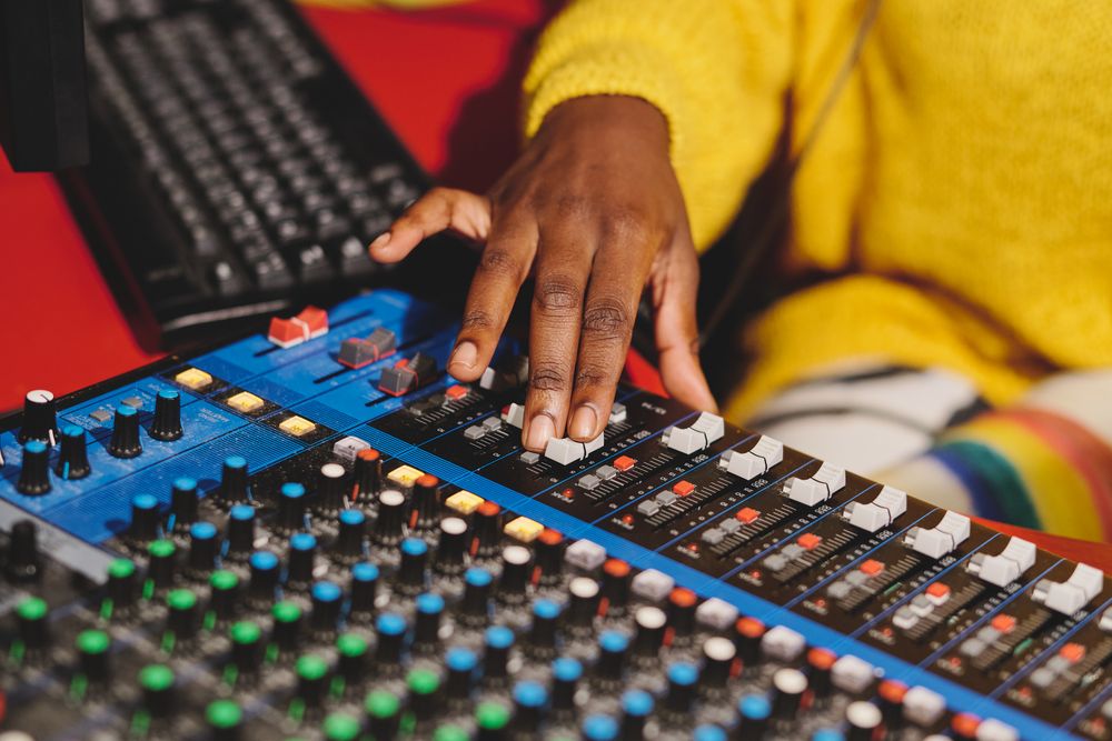 Crop Black woman using mixing console