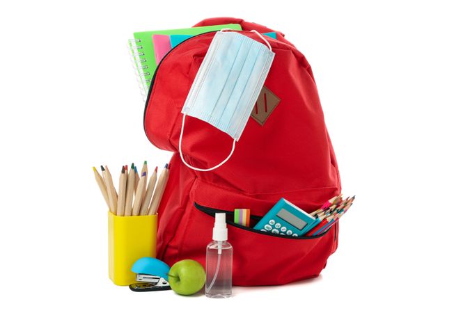 School supplies with medical mask and sanitizer isolated on plain background