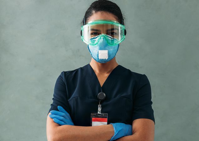 Portrait of Black female doctor with arms crossed in PPE gear