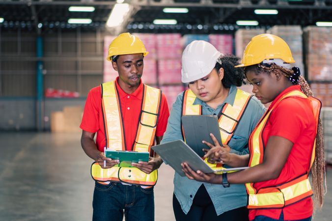 Three colleagues working together on stock in factory