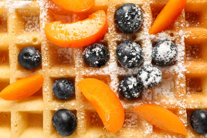 Waffle with fruits and powdered sugar as background