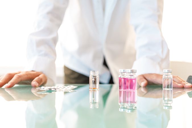 Faceless assistant working with medical samples and pills
