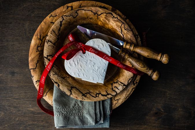 Valentine's day card concept of heart ornament on rustic plate