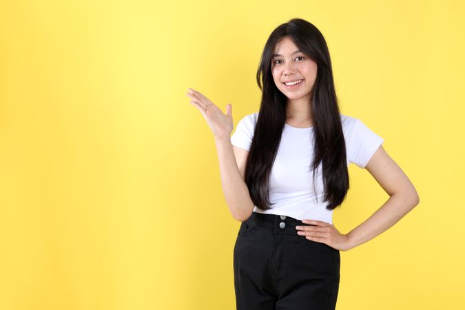 Portrait Asian Beautiful Young Woman in White Shirt Smiling Standing Pointing and Hand on Hips