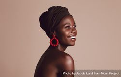 Close up of smiling African woman on beige background bEQnMb