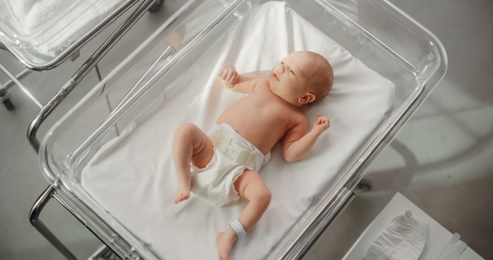 Adorable Newborn Child Lying in Hospital Bed in a Nursery Clinic.