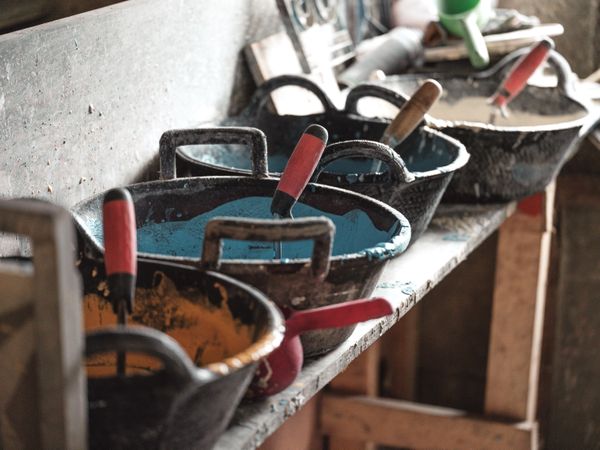 Colorful glaze in bowls on shelf in workshop