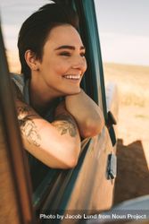 Close up of happy woman leaning out of window of classic truck on road trip 5oAMmb