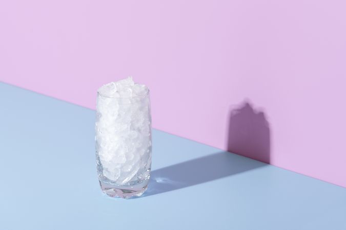 Glass of ice on a blue table in bright light