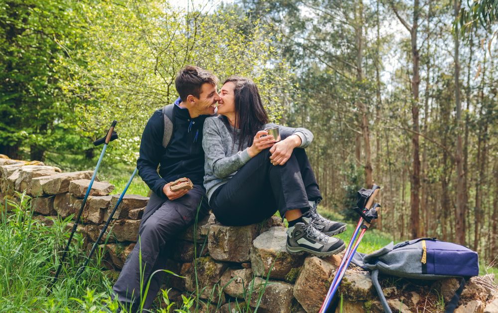 Couple about to kiss while making a break to do trekking
