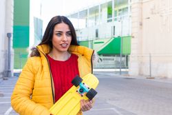 Young woman with skateboard on street