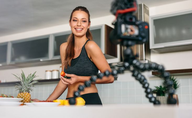 Fit vlogger creating new juice recipe in kitchen