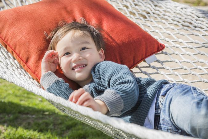 Cute Biracial Young Boy Relaxing in Hammock