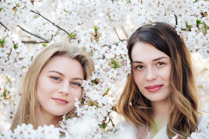 Portrait of women friends near blooming trees