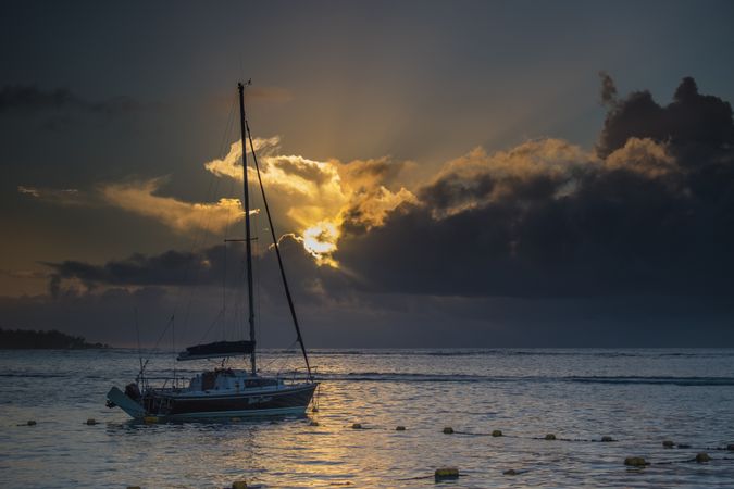 Sailboat anchored in Indian Ocean with the sunsetting in the background