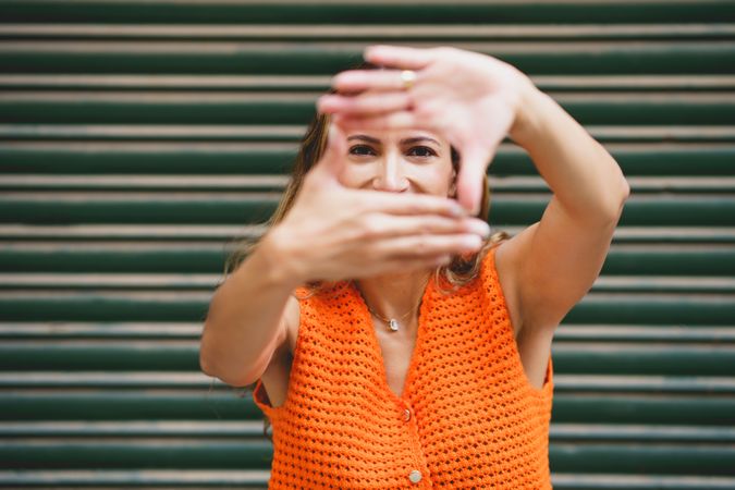 A latin woman framing with hands outdoors