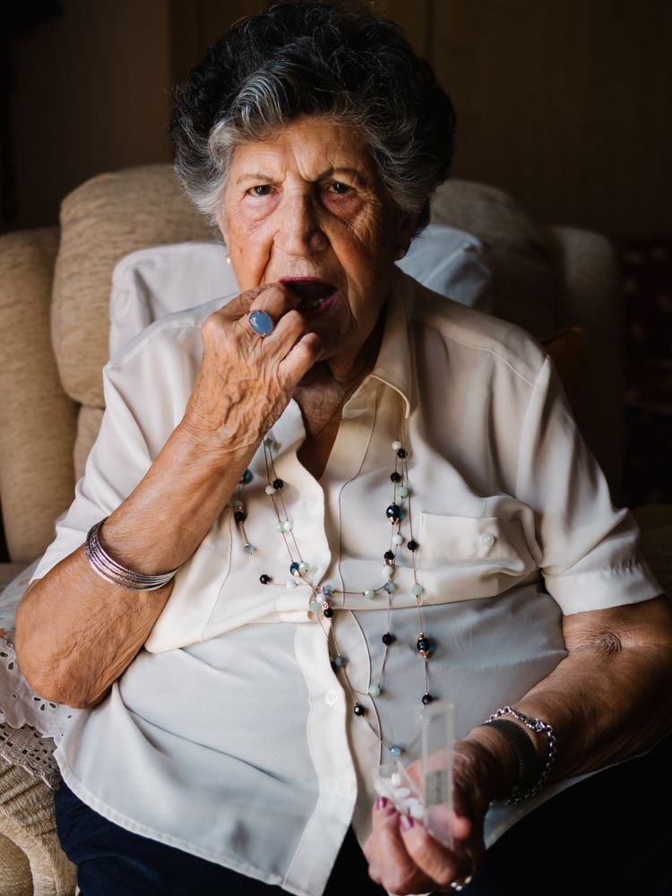 Older woman taking pills at home