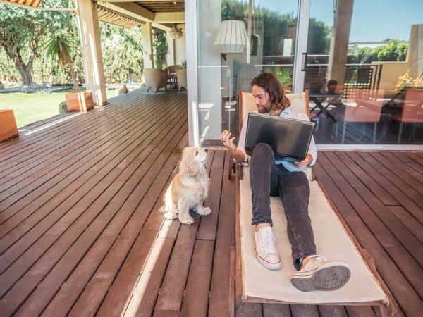 Man with laptop giving apple core to dog