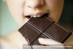 Unrecognizable young girl biting into delicious chocolate bar 5wXgWL