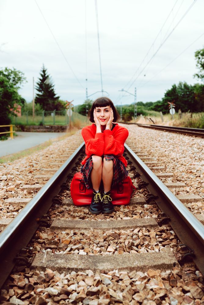 Woman sitting on sleepers in middle of railway