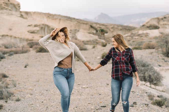 Blond women holding hands on nature