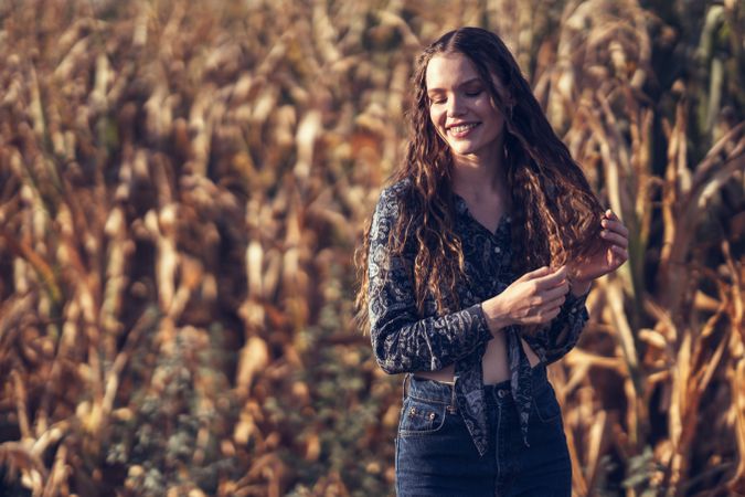 A Young Woman With a Bright Smile Enjoying the Splendor of a Beautiful Cornfield in Autumn