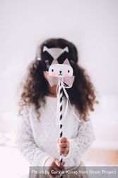 Little girl wearing an animal mask holding a wand n56Nx5