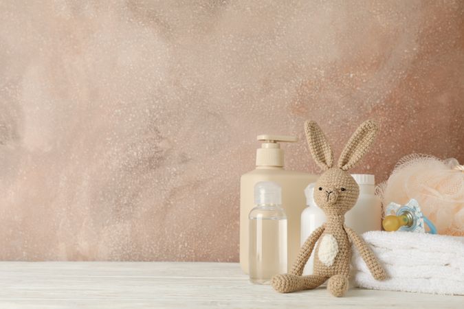 Baby hygiene accessories on wooden table against brown background