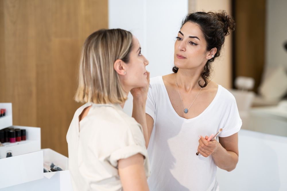 Woman having her make up professionally applied in salon