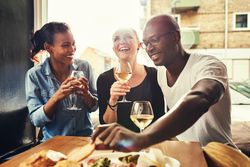 Three good friends drinking wine in a bright tapas restaurant