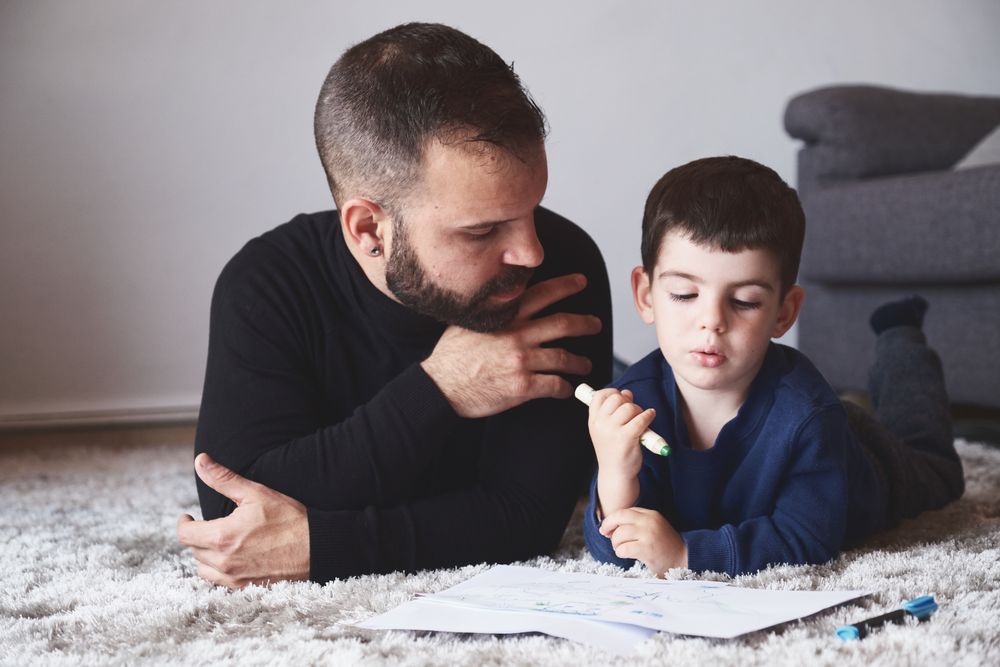 Father and son drawing on floor