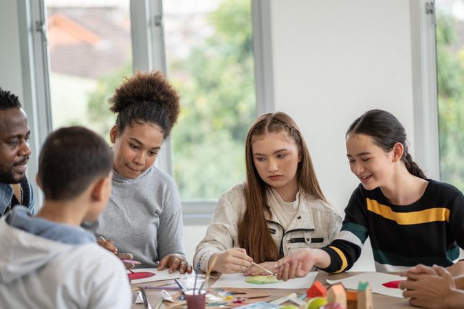 Young teens in painting class at school with space for text