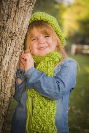 Portrait of Cute Young Girl Wearing Green Scarf and Hat