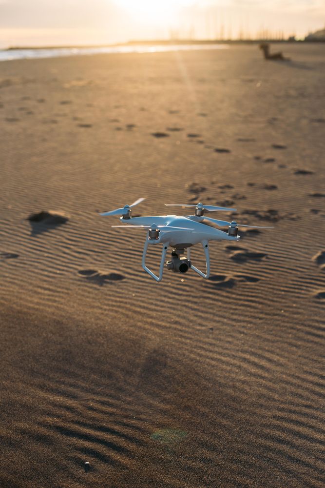 Drone flying close to sandy beach