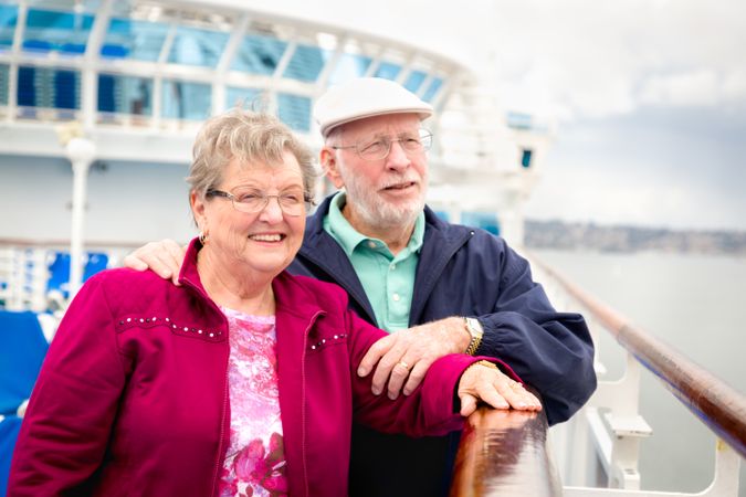 Content Mature Adult Couple Enjoying The View From Their Passenger Cruise Ship Railing.
