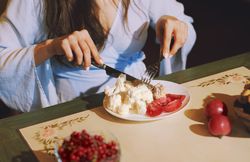 Vegetarian woman sitting at the table and eating healthy food