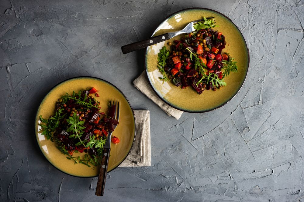 Top view of two beet salads served on yellow plates with copy space
