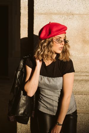 Stylish female standing near building wall