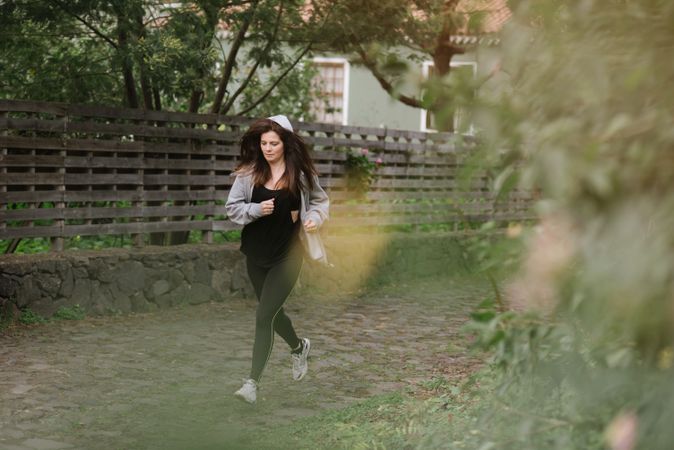 Positive woman running in park