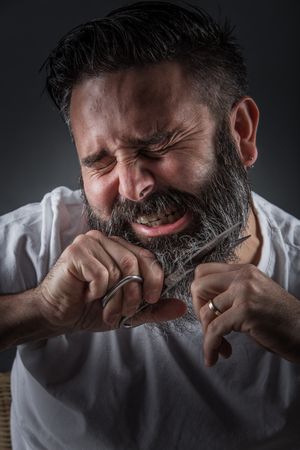 Expressive barber cutting beard