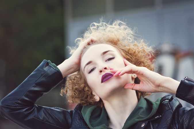 Curly haired female in leather jacket in city