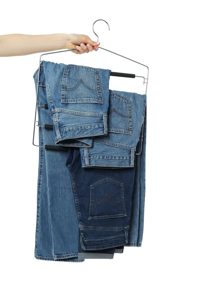 Jeans on hangers, isolated on light background