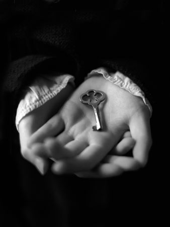 Close-up of a young woman's hands, delicately holding a small antique-looking key