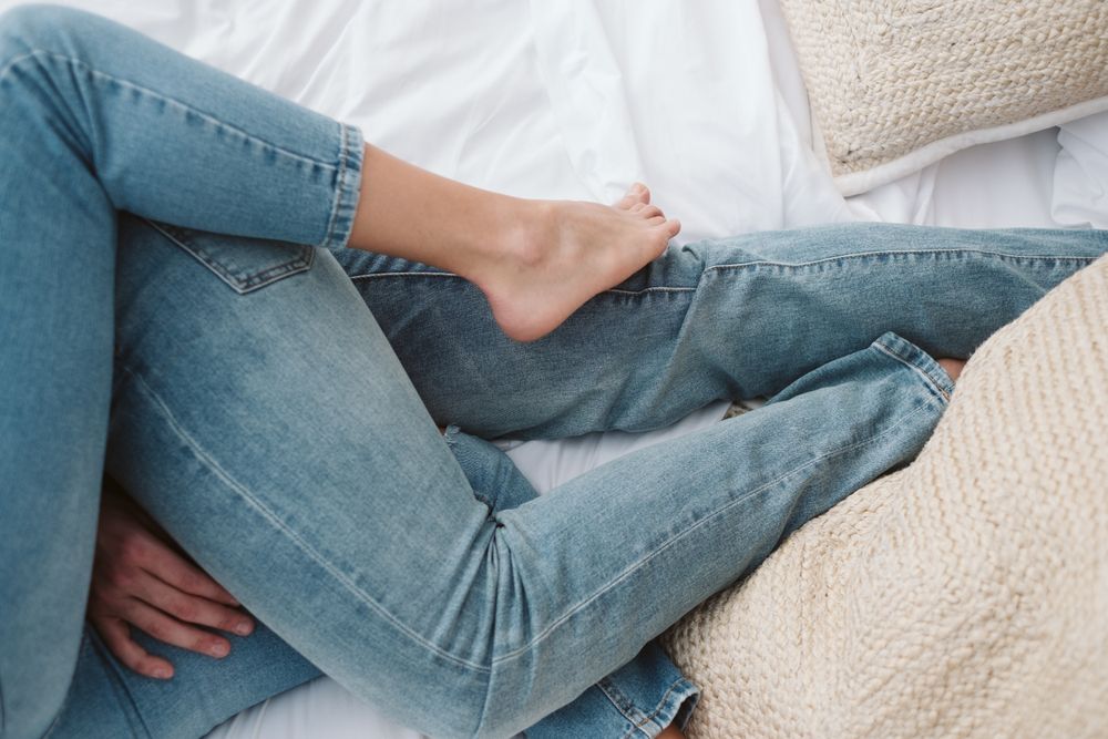 Passionate couple in jeans lying on bed