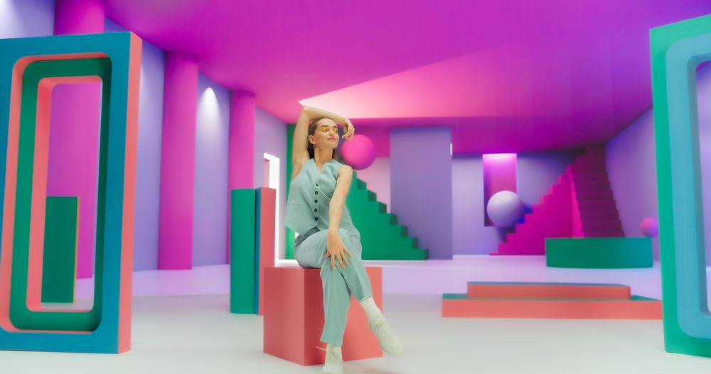 Woman with Bright Makeup Dancing Energetically and Interacting with Colorful Geometric Abstract Environment. Creative Young Female Happily Performing Dance with Dynamic Movement