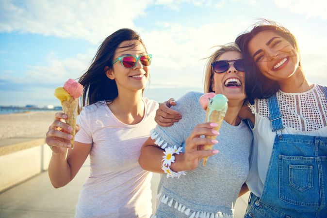 Happy female friends eating ice cream in the sun