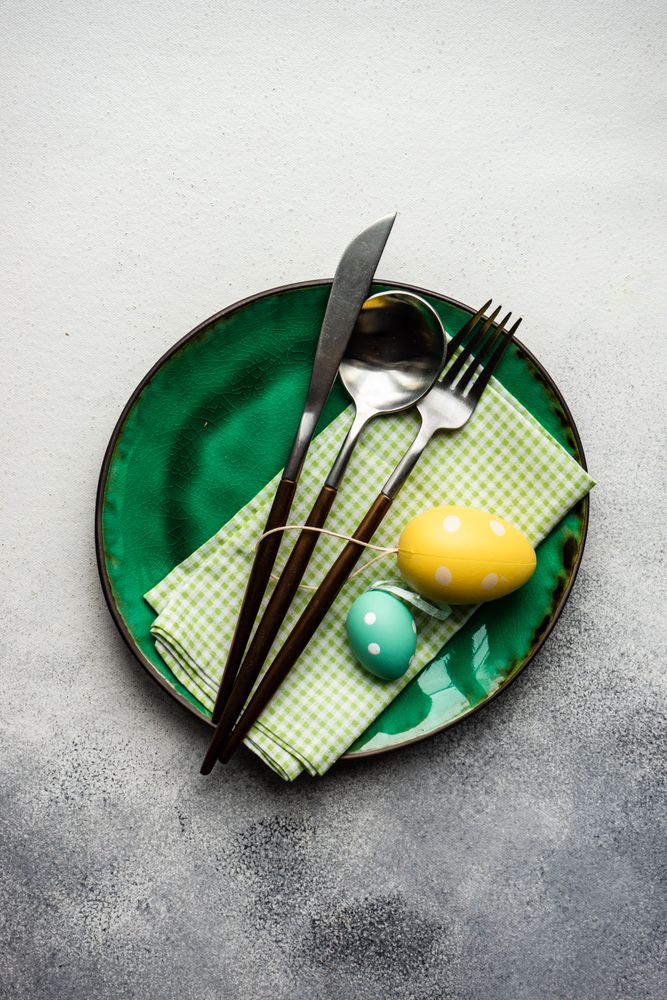 Easter table setting with green plate and colorful egg ornaments
