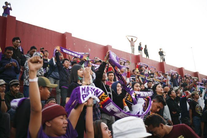 Kedira, East Java Indonesia - October 4, 2019: Soccer fans holding up purple banners